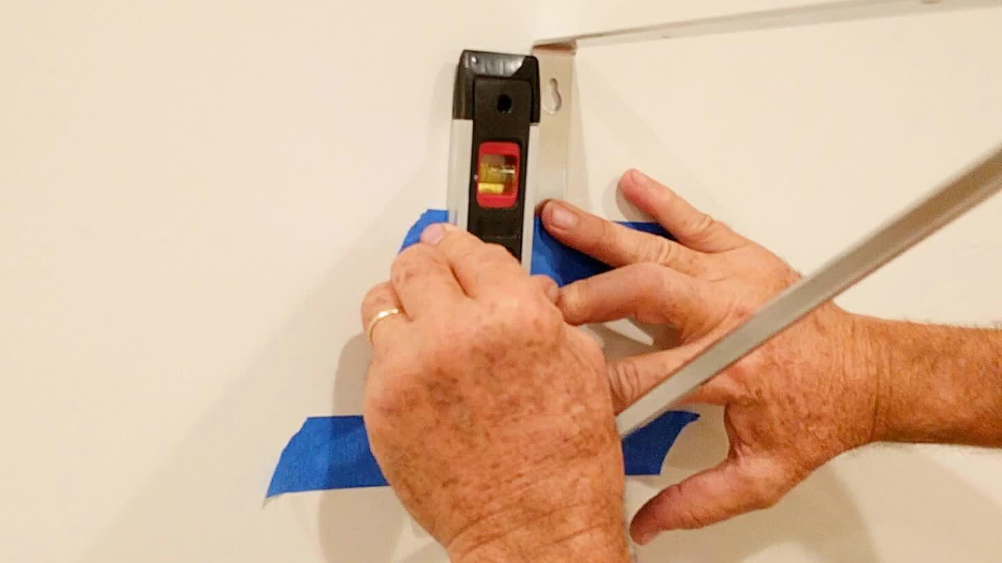 Measure where you are going to install the brackets and tape it to the wall. Use a leveler to make it sure it's properly aligned. After you tape two brackets, use a longer leveler to see if both are aligned, then drill the wood slabs to it.