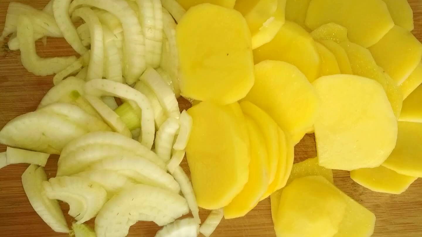 Oloupané brambory a fenykl nakrájíme na plátky. Povaříme asi 15 minut na mírném ohni v zeleninovém vývaru s bobkovým listem, solí a pepřem.