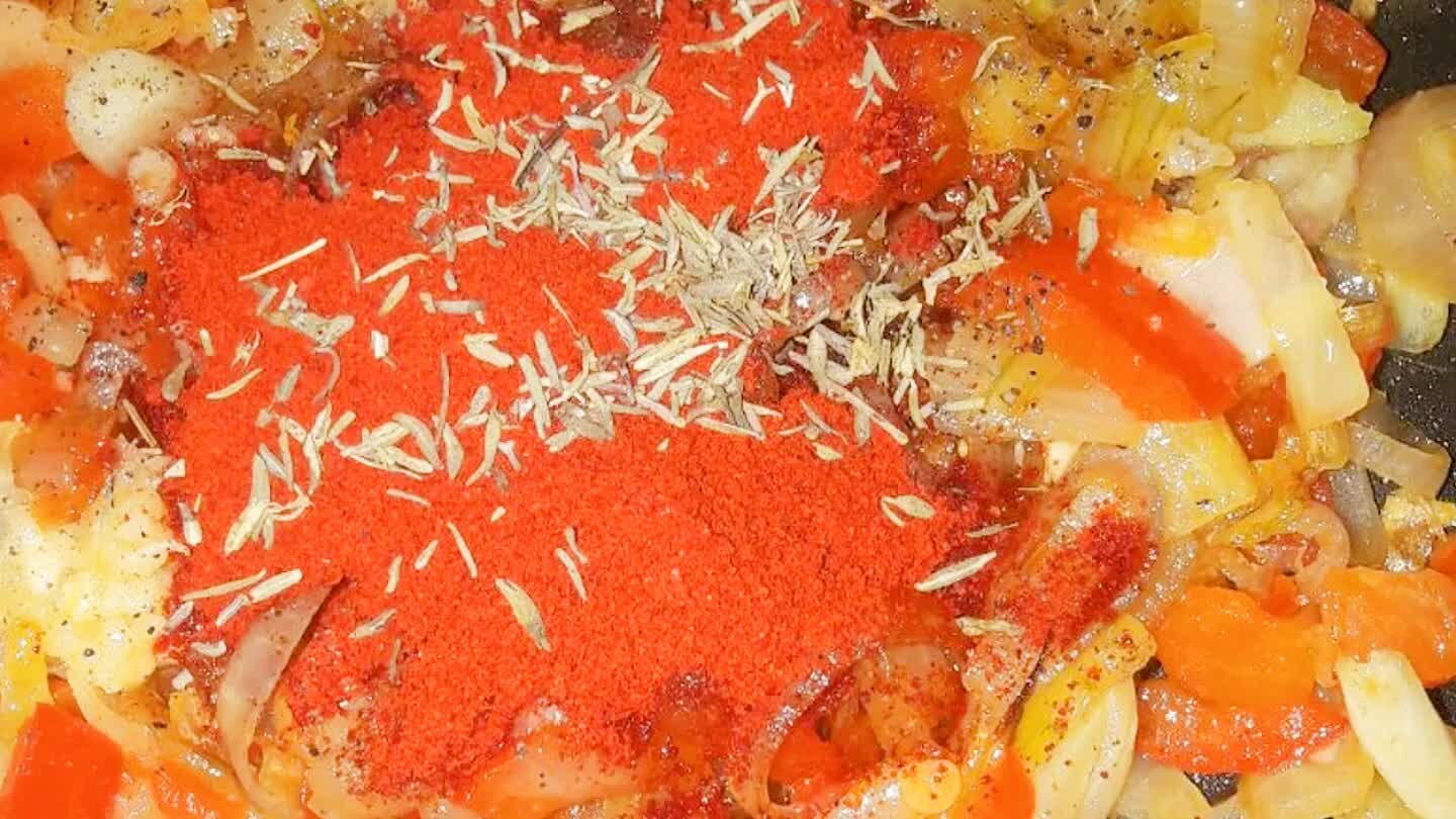 When the onions are translucent and cooked, we add very generous amount of sweet paprika with some hot paprika, black pepper and thyme. Keep in mind that the potatoes are going to cook in it, so add a lot. Make sure its salty enough.