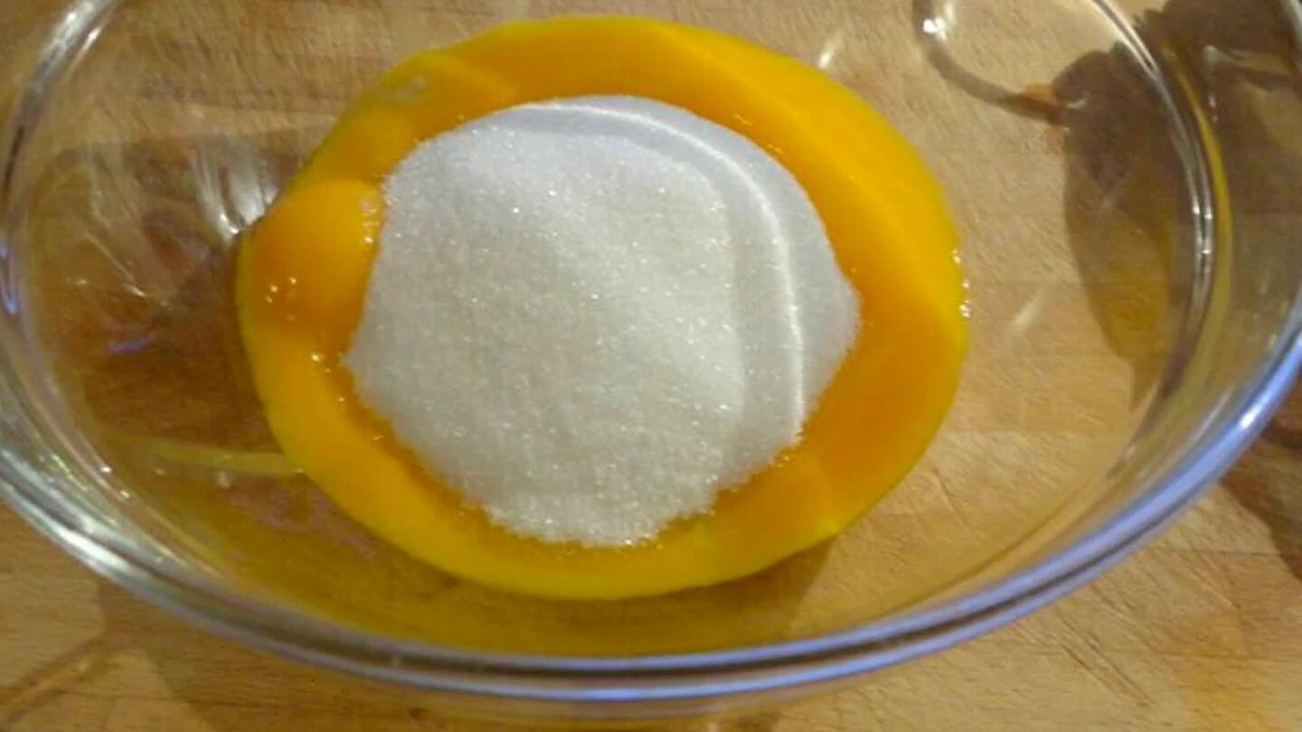Casser les œufs dans un grand bol puis fouetter avec le sucre jusqu'à ce que le mélange blanchisse et devienne mousseux..