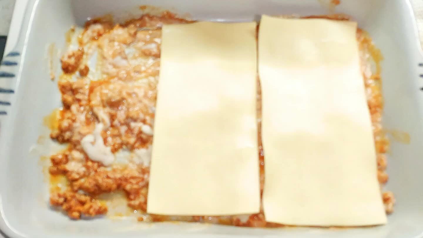 indi creare il primo strato di lasagne. Seguire la stessa procedura per tutti gli strati. Tra uno strato e l'atro mettere le fette di formaggio.