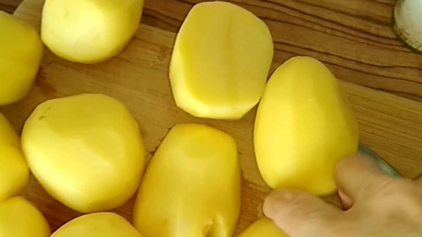Syrové brambory nakrájet na plátky. Půlku naskládat do pekáče, osolit.
