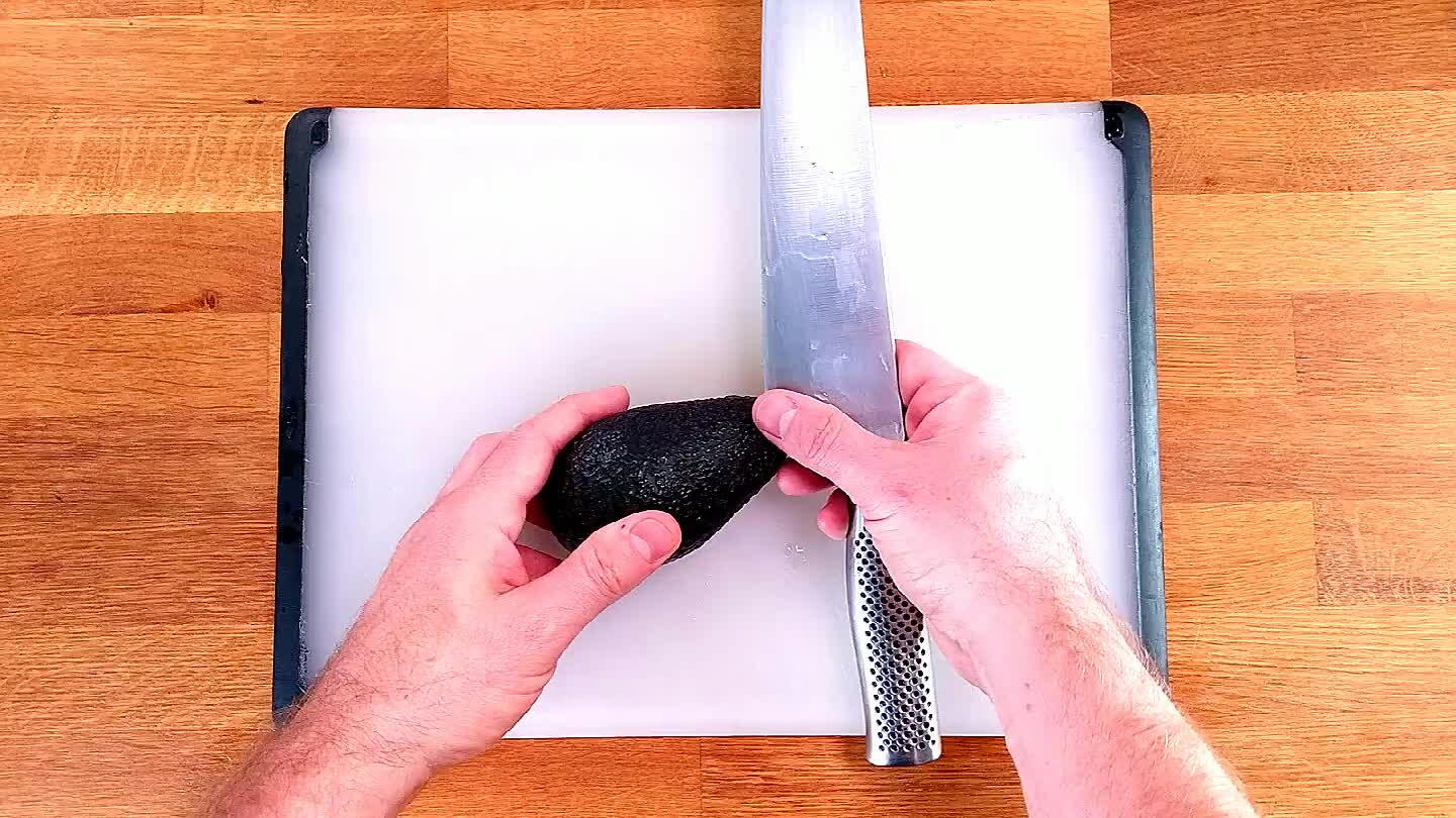 r line of the pit. Now, you don't move the knife, you move the avocado. Roll the pit of the avocado along the blade of the knife to slice in half perfectly.