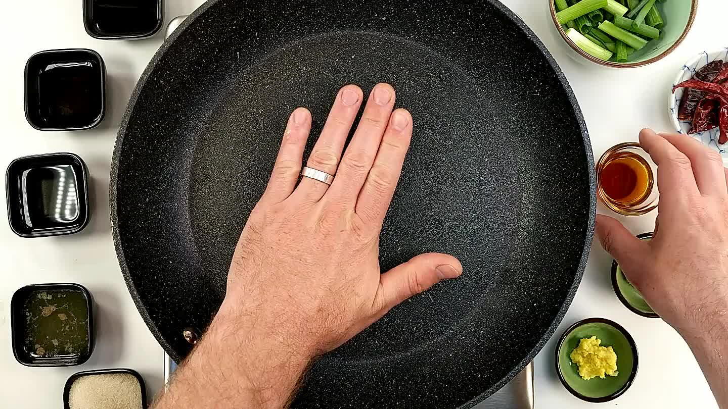 Scalda un po' di olio di sesamo in una padella antiaderente e cuoci brevemente l'aglio schiacciato e lo zenzero grattugiato.