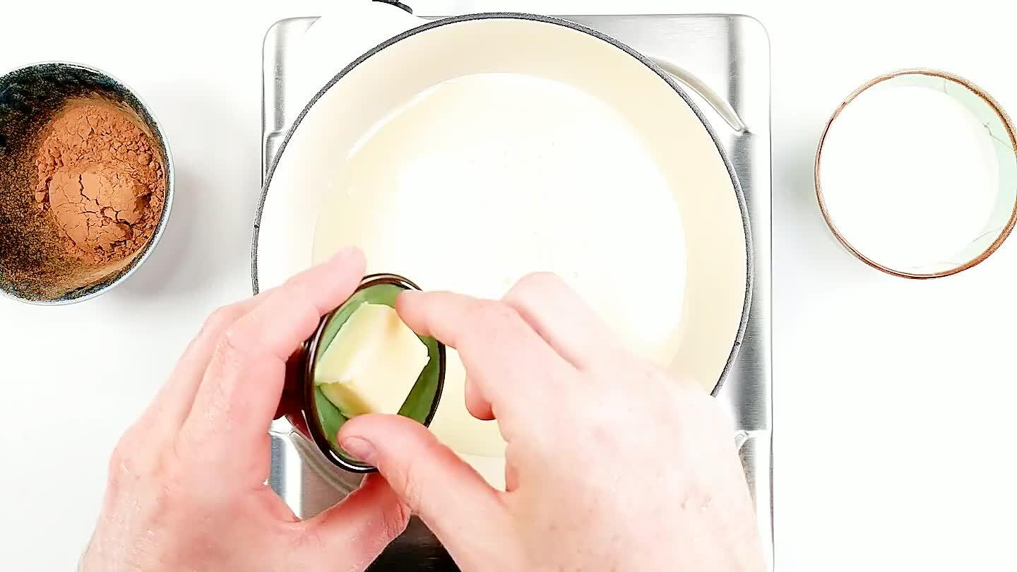 Despeje o leite condensado numa panela grossa e adicione a manteiga.