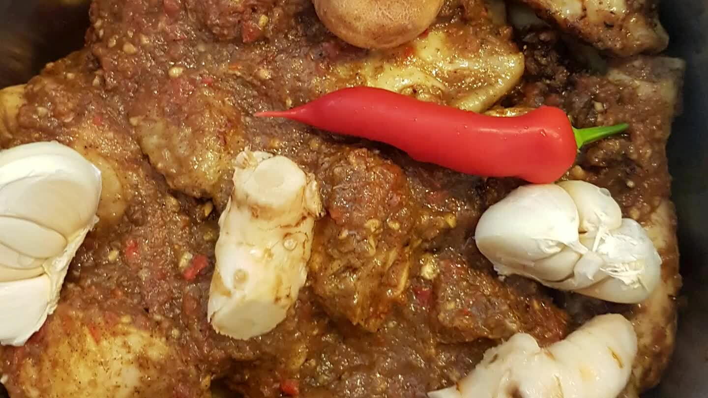 ag paprikaplakken, laag tomatenschijven en een laag aardappelschijfjes. Leg de knoflookbol waarvan de meeste losse velletjes zijn verwijderd er boven op. Zo ook 2 chillis, de gedroogde limoen en de laosstukjes. Daarbovenop gaan de stukken kip. Deksel op de pan en breng het aan de kook. Vuur laag en 15 tot 20 minuten zacht laten koken.