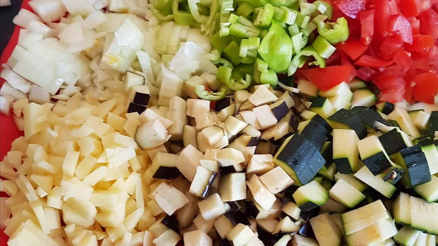 zaadjes van de tomaten en snij deze ook in grove stukken. De aardappelen in kleine stukjes. Hak de knoflook fijn.