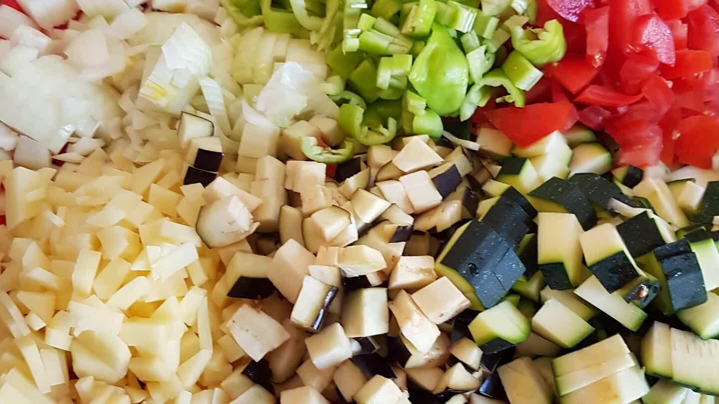 zaadjes van de tomaten en snij deze ook in grove stukken. De aardappelen in kleine stukjes. Hak de knoflook fijn.