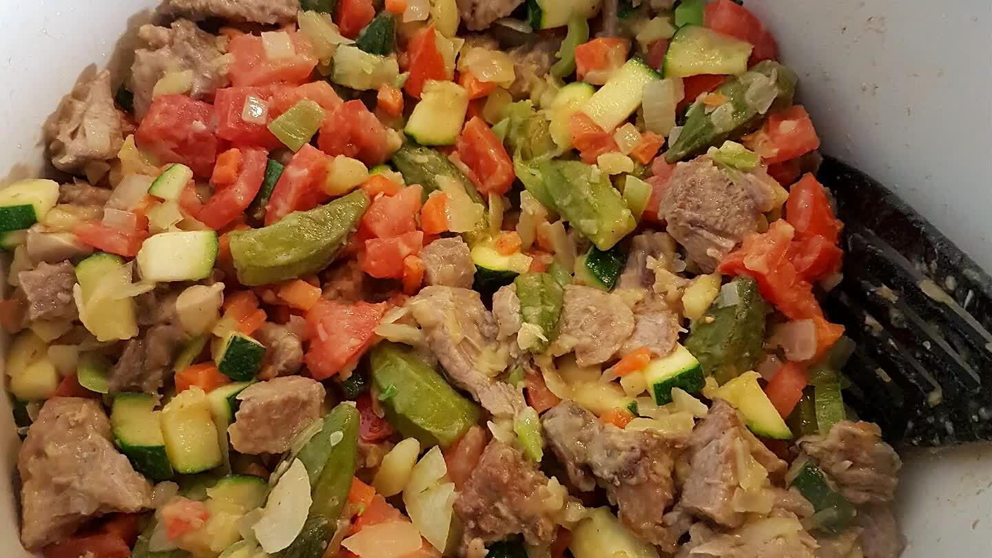 n vervolgens de aubergine weer even roeren en pepers, dan de tomaten. Als alles in de pan zit even kort de tomatenpuree meebakken en 3 blikjes water toevoegen, ook het vlees kan er nu bij.