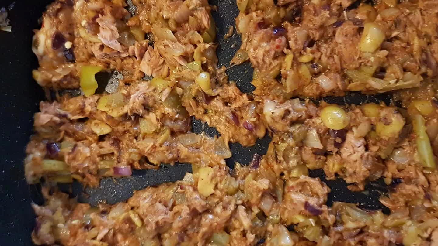 Voeg de gegrilde paprika, zwarte olijven, zout, paprikapoeder, knoflookpoeder, uienpoeder, zwarte peper en bruchetta kruiden toe. Bak voor 2 minuten samen. Voeg de tonijn en geraspte kaas toe en bak 1 minuut mee. Zet het vuur uit en laat t staan.