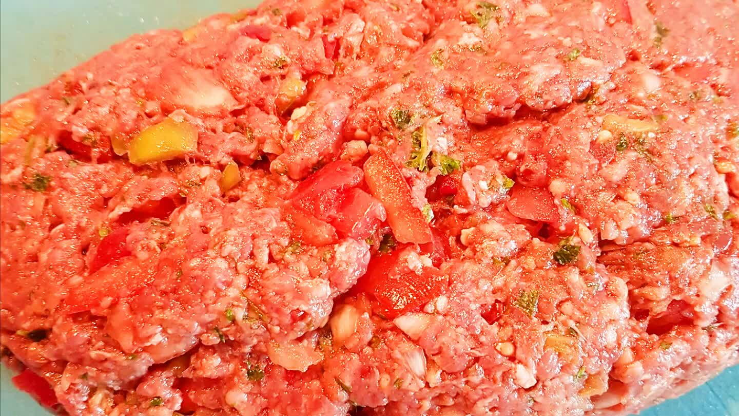 en voeg als laatste de olie en de tomatenpuree erbij, nog even doorkneden en zet het gehakt in de koelkast.