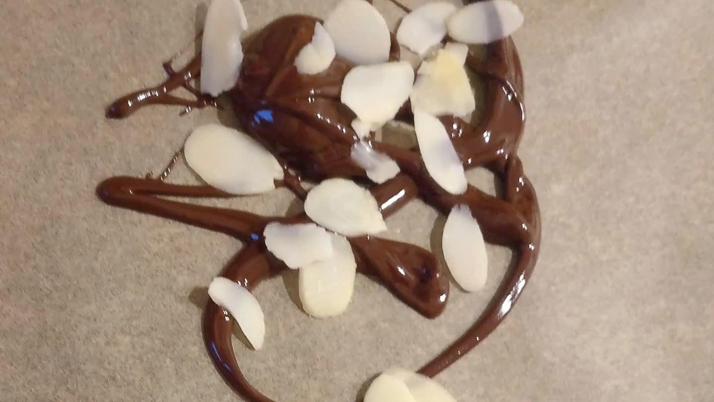 Calenté al baño maria el chocolate hasta que estuviera disuelto y liquido, (no pares de moverlo) despues sobre un papel de horno hice la filigrana de chocolate, decore con almendras lanimadas y deje que se enfriase en el frigorífico. Reservar hasta la presentación