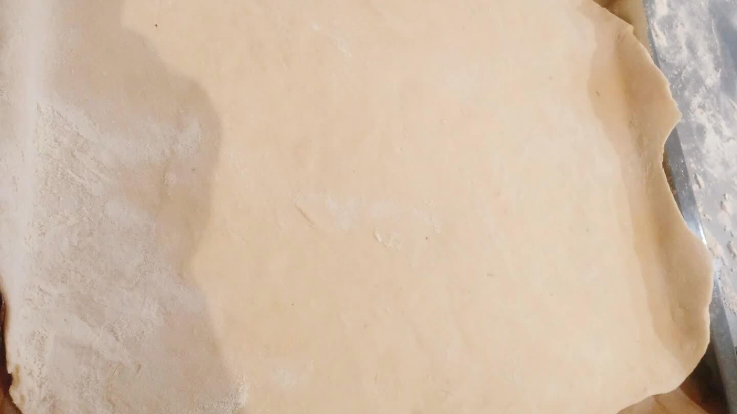 ona de trabajo y extendemos una mitad de la masa hasta conseguir una pieza suficientemente grande como para cubrir la bandeja. Extendemos el sofrito de pimientos y cebolla, añadimos las aceitunas cortadas y el atun. Colocamos la otra mitad de la masa (extendida) y cerramos los bordes haciedo pequeñas dobleces.