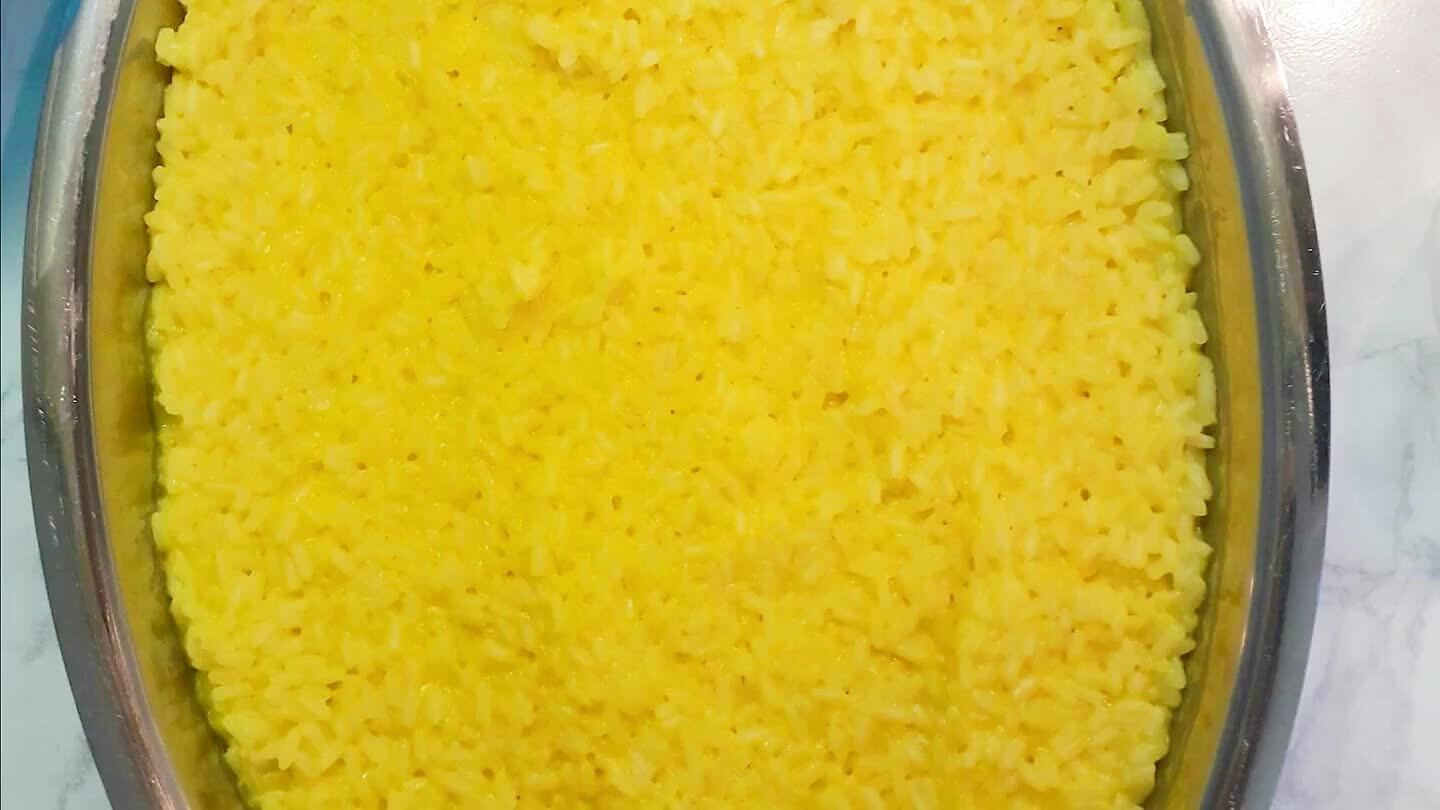 acqua. Qualche minuti prima della fine della cottura, aggiungere una bustina di zafferano, un pezzettino di burro e il parmigiano. Girare bene e fare asciugare. Versarlo in un vassoio a bordi alti e far raffreddare.