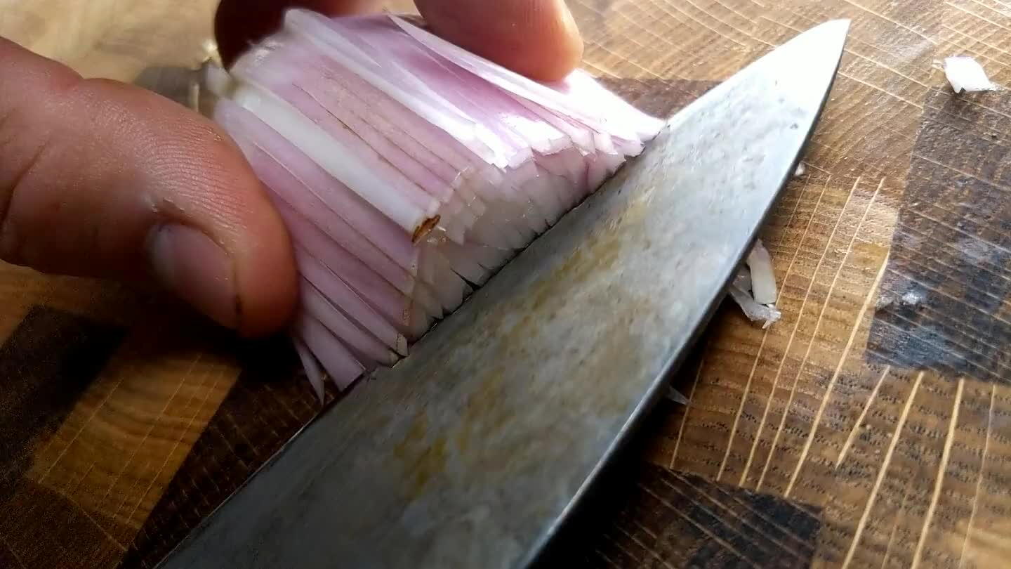 dicular to your previous cuts. Again, don't slice through the back of the shallot. You want the fine strips of shallot to remain connected to the root end so that they'll be easier to slice in the next step. Watch those fingers.