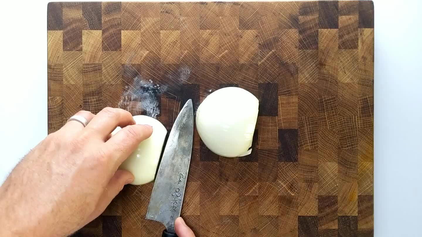 ife parallel to the cutting board. Don't slice through the root tip of the onion. Dice the onion.