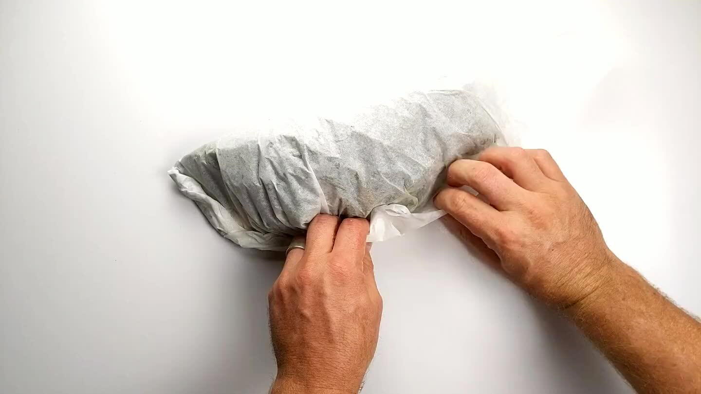 continue along the open side of the parchment, folding/rolling the edge in towards the contents until you get to the opposite corner. Tuck the opposite corner under the roll.