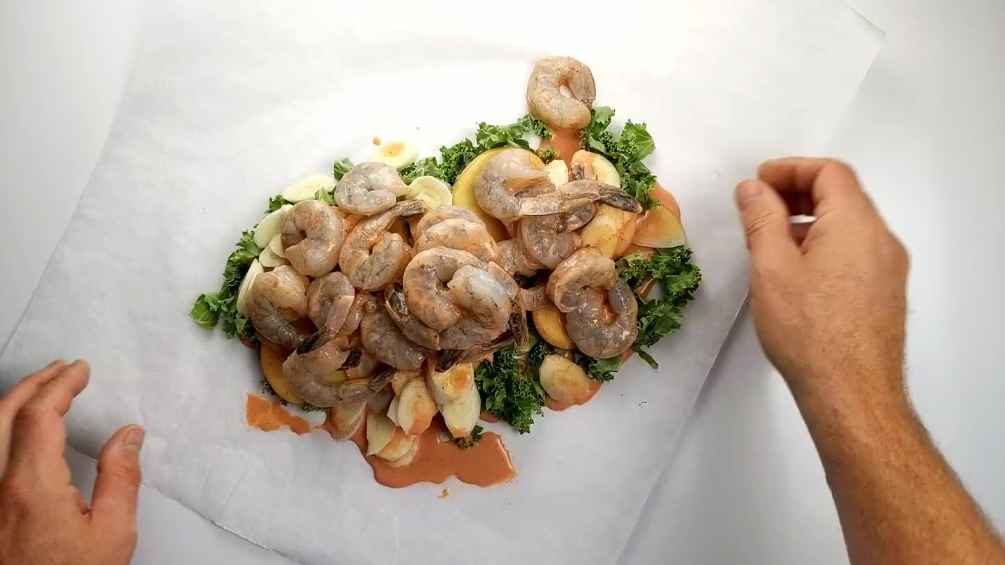 continue along the open side of the parchment, folding/rolling the edge in towards the contents until you get to the opposite corner. Tuck the opposite corner under the roll.