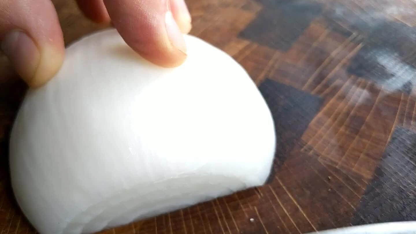 some of the stem end of the onion to leave a flat face that looks like a little onion rainbow. Slice a hatch pattern into that face. Then slice from the top to a fine dice.
