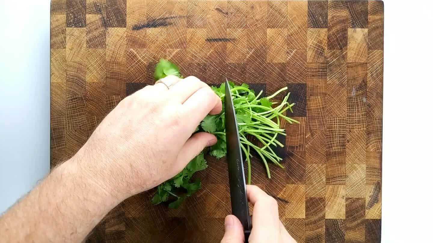 d the bottom half of the stem. Roll the cilantro up into a pile and give it a rough chop.