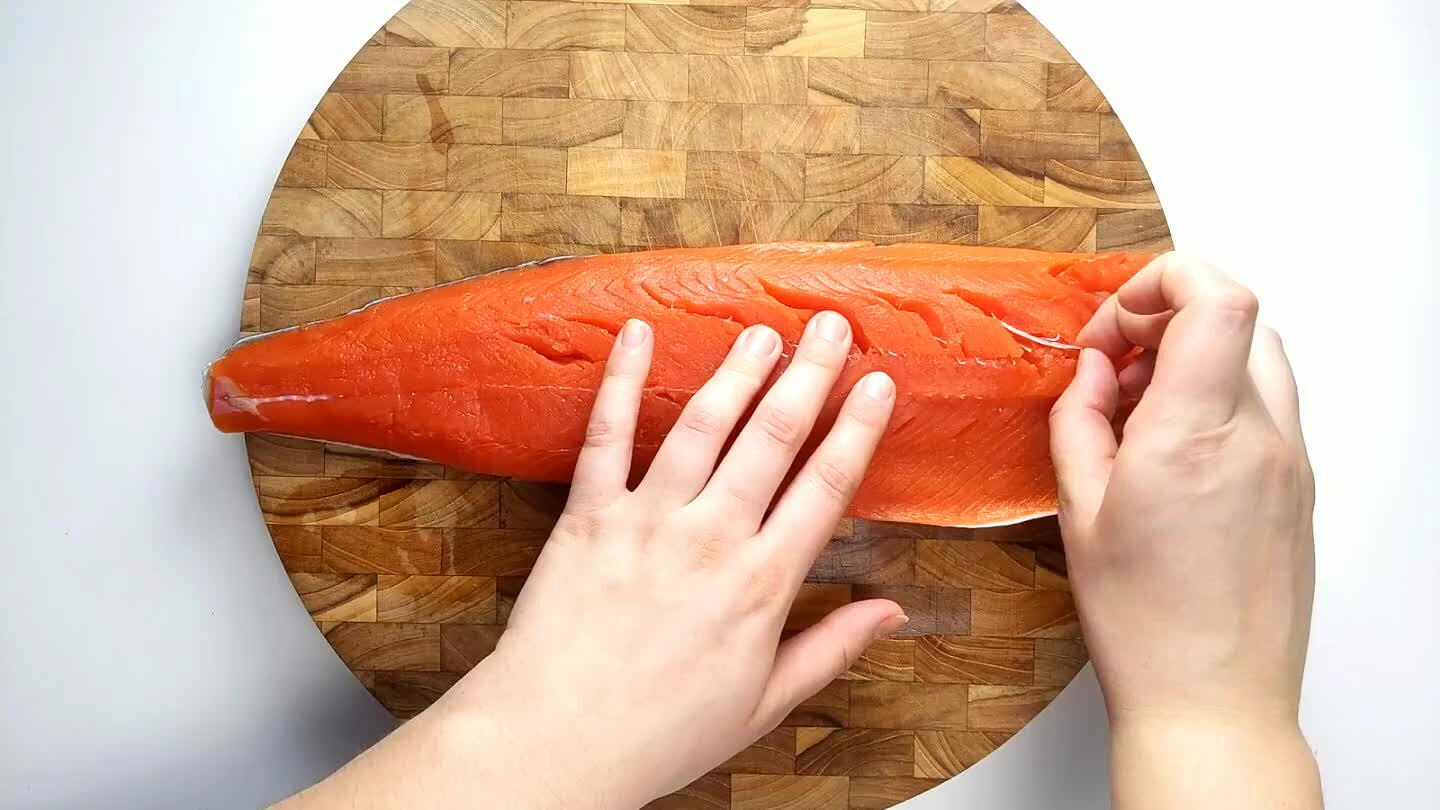 the fillet if there are any. Remove the skin by sliding a sharp knife between the skin and the flesh of the salmon.