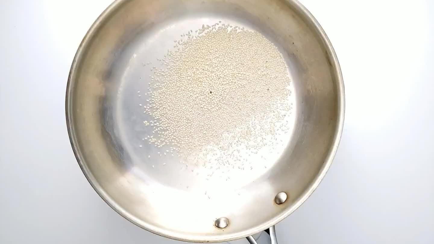 g constantly until they begin to darken in color. Remove from heat and continue shaking the pan to keep the seeds moving. When the seeds are golden brown, transfer them to a cool dish. Garnish the noodles with toasted sesame seeds.