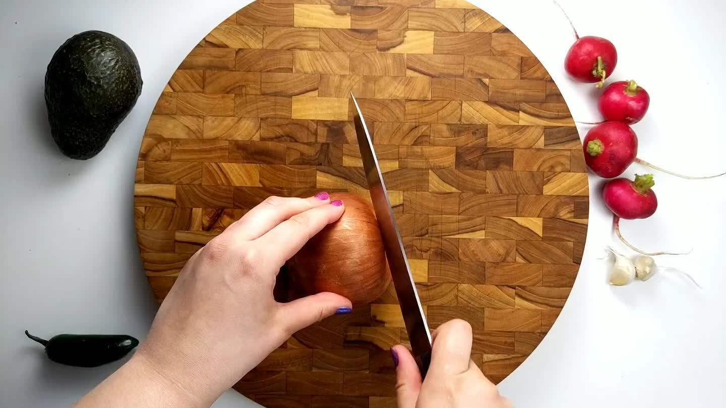 the cutting board, cut the onion in half, leaving the root side intact. Then slice thin strips across the onion toward the root. Chop perpendicularly to create the dice.