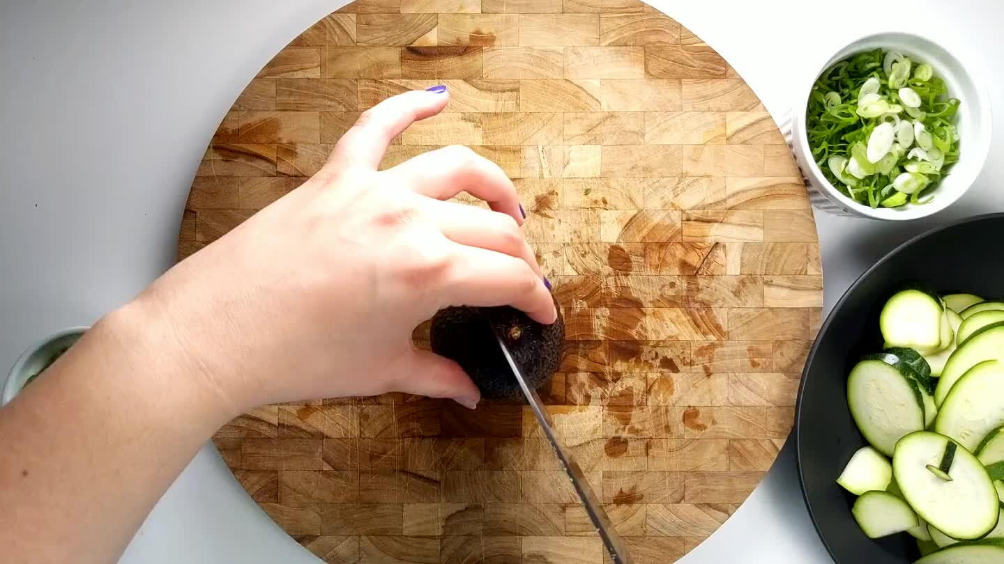 remove the avocado pit with the blade of the knife. Carefully slice into strips.