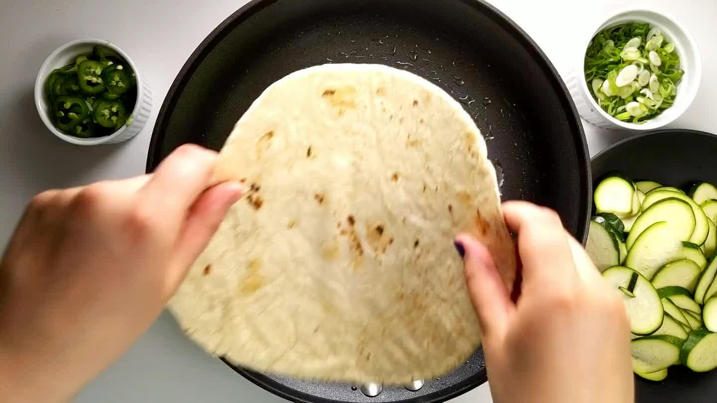 e olive oil on the tortilla. Add 1/2 cup of cheese per quesadilla putting half on the bottom and half after you add the toppings. Next layer the thinly sliced zucchini. Top that with sliced jalapenos.