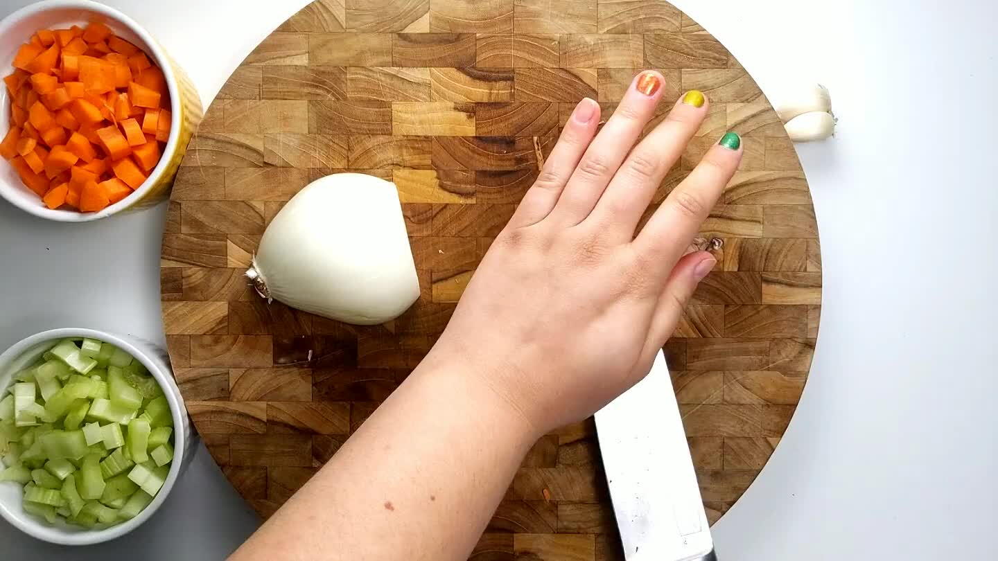 n face of the onion. Then turn the knife back and slice across into thin strips. Cut perpendicularly to create a small dice.