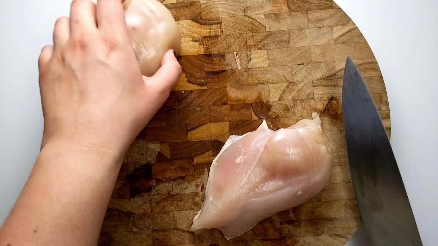 lat on top keeping your fingers out of the way and sliding the knife through the middle of the breast.
