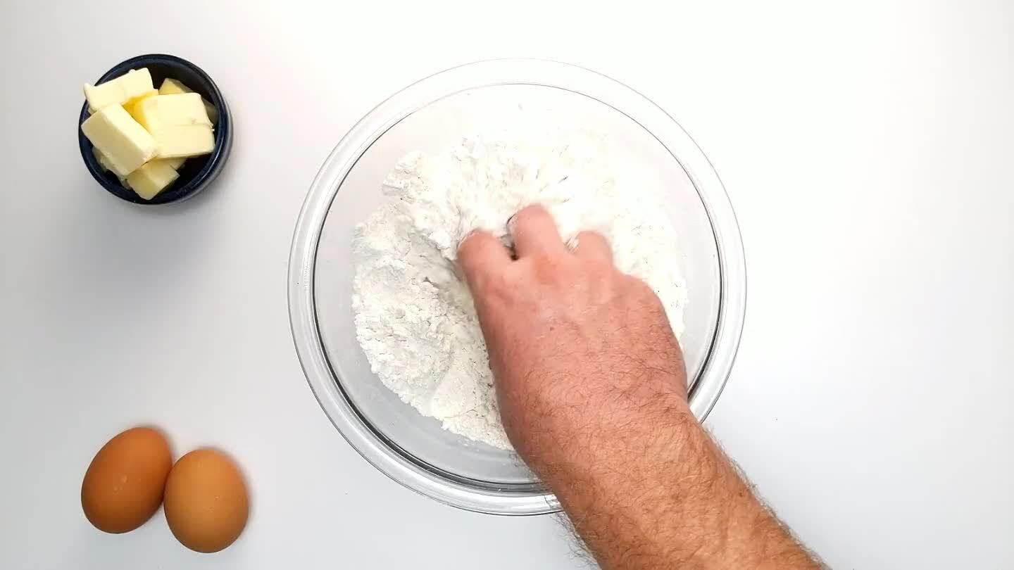 to handle if you dice it first. Cut in the butter with a pastry blender until well mixed. You should no longer see any chunks of butter, and the resulting dough should clump together when squished in your hand. If you don't have a pastry blender, freeze the butter and grate it on a cheese grater, then mix it with the flour with a fork, or with a few pulses in a food processor.