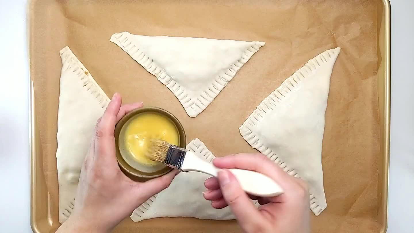 tops with a light coat of egg wash being careful not to let it drip off the edges.