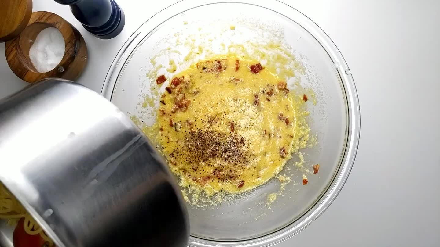 e cominciate a mescolare subito, velocemente. L'acqua calda in eccesso degli spaghetti si unirà al composto, sciogliendo il formaggio e trasformando delicatamente l'uovo in una salsa liscia e cremosa. Se la salsa risultasse troppo densa, aggiungete un po' dell'acqua della pasta che avete tenuto da parte (attenzione: è salata). Se la salsa è troppo liquida, mettete la ciotola nel microonde per 30 secondi e poi mescolate, ripetendo l'operazione finché non raggiungete la consistenza desiderata.