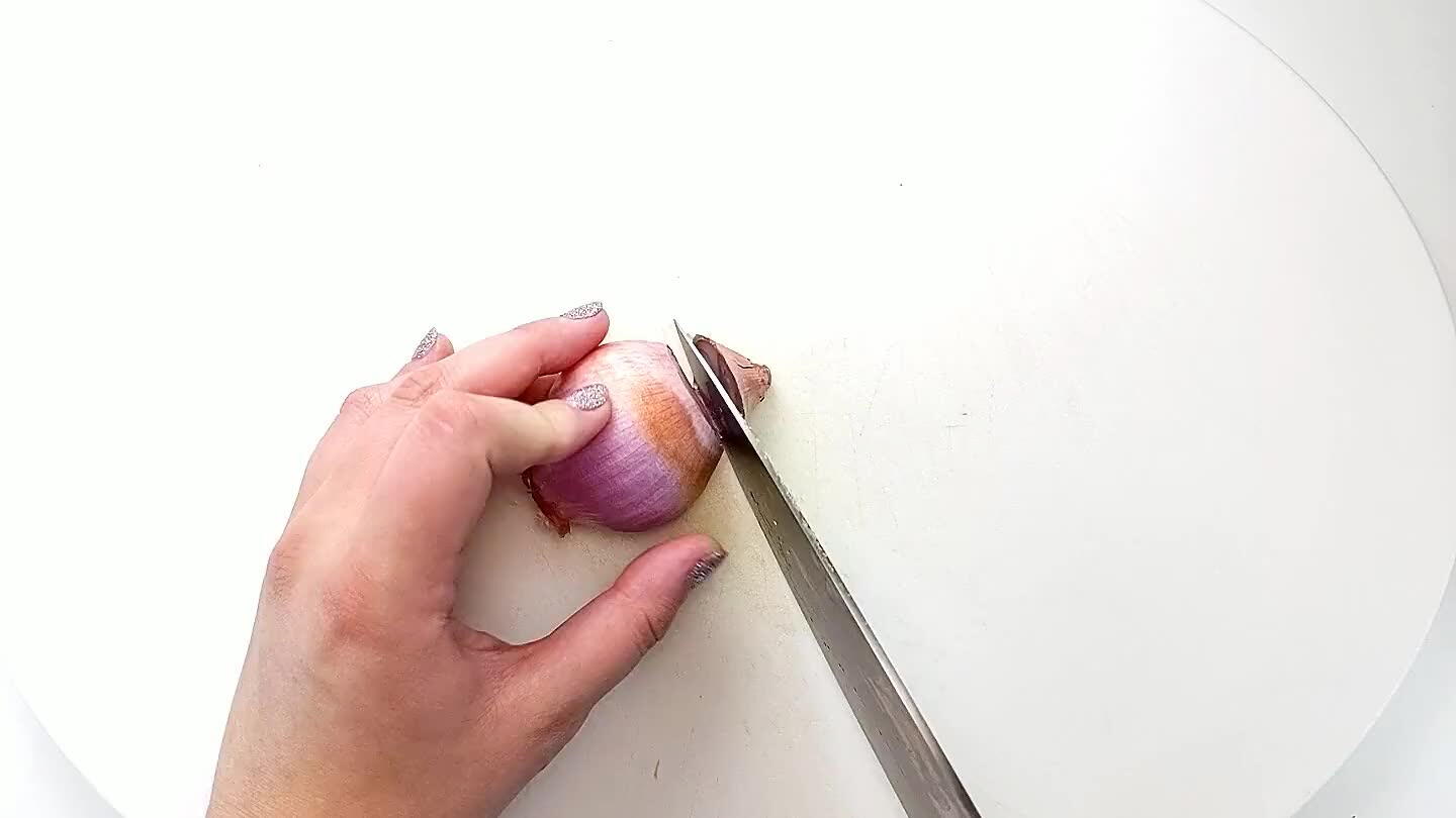 in tact. With the knife parallel to the cutting board, make two or three even cuts into the side of the shallot.