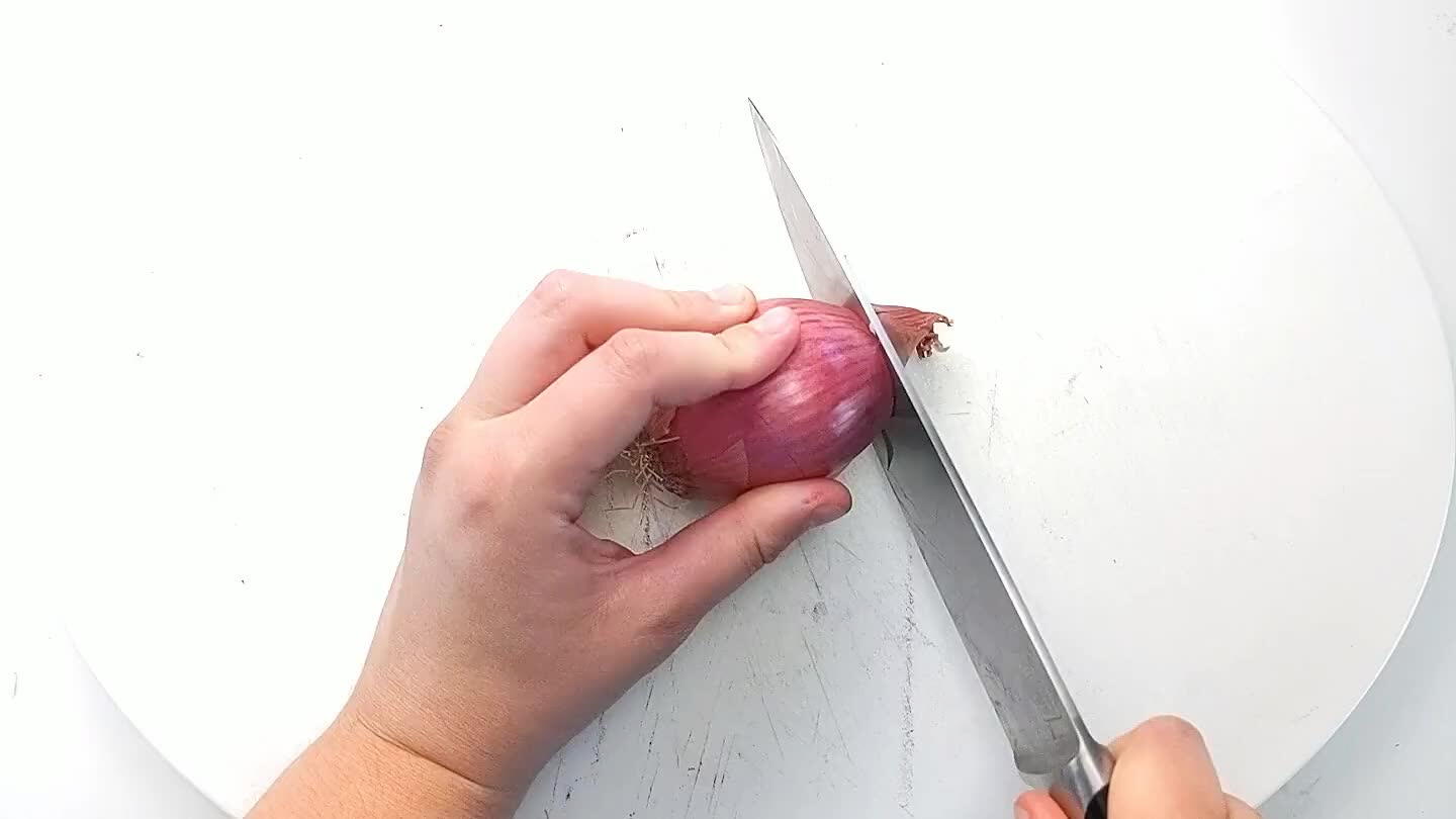 in tact. With the knife parallel to the cutting board, make two or three even cuts into the side of the shallot.