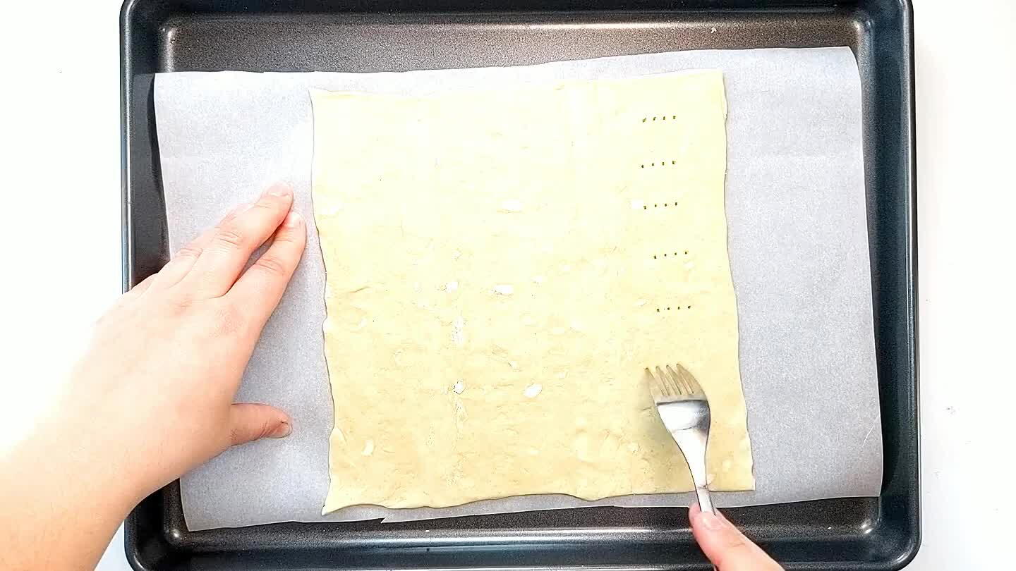 r. Prick the puff pastry with the tines of a fork. Mix the egg with a tablespoon of water and brush it over the puff pastry.