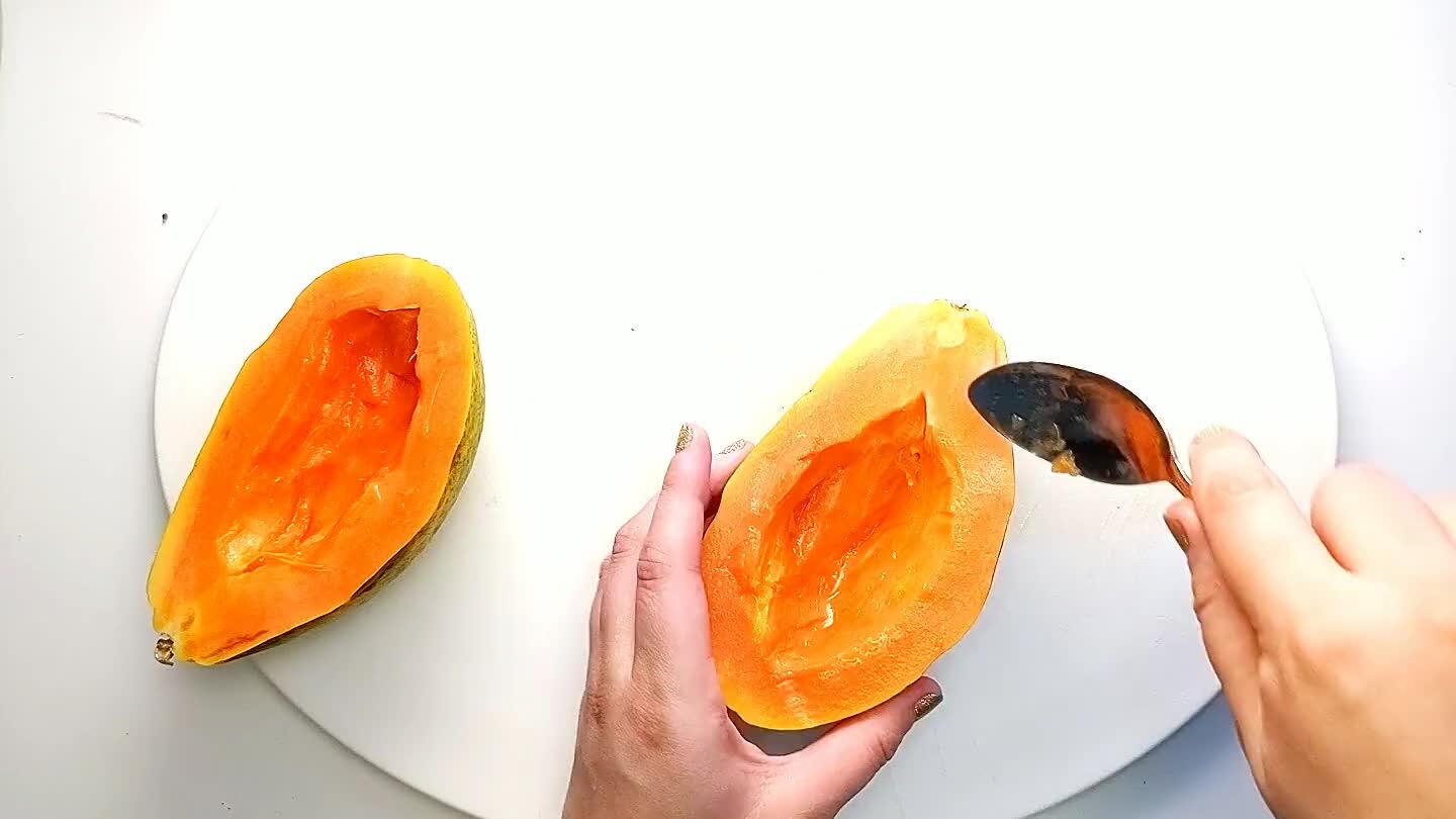 so around the outside to create a bowl for the smoothie. Reserve the scooped out papaya for the smoothie.